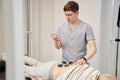 Physiotherapist checking the screen of NMES device Royalty Free Stock Photo