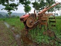 A manual tractor made of steel for plowing rice fields used to prepare land for rice cultivation.