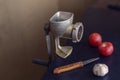 Manual vintage meat grinder, knife and vegetables on the table Royalty Free Stock Photo