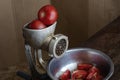 Manual vintage meat grinder and ripe tomatoes on the table Royalty Free Stock Photo