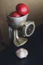Manual vintage meat grinder and ripe vegetables on the table Royalty Free Stock Photo