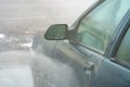 Manual washing of the car with water under pressure on the car wash outside. Summer car wash. Cleaning the car with high-pressure