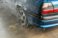 Manual washing of the car with water under pressure on the car wash outside. Summer car wash. Cleaning the car with high-pressure