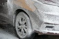 Manual washing of the car with water under pressure on the car wash outside. Summer car wash. Cleaning the car with high-pressure