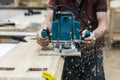 Manual wood concept. Cropped close up photo of cabinetmaker handcraft tradesman with electric tool in hands make furniture in