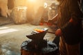 Manual work of a blacksmith in a blacksmith Shop. Hammer blows on the iron billet on the anvil. Forging sword blades is