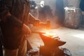 Manual work of a blacksmith in a blacksmith Shop. Hammer blows on the iron billet on the anvil. Forging sword blades is a retro