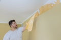 Manual work with scraper worker hand scraping old wallpaper on wall with preparation for painting a room Royalty Free Stock Photo