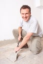 Manual worker disassembling old floor tiles