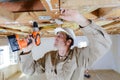 manual worker drilling ceiling with drilling machine