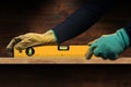 Manual Worker Holding an Orange Spirit Level on a Wooden Plank Royalty Free Stock Photo