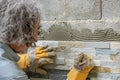 Manual worker tiling a wall