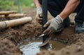 Manually drilling well with auger drill. Operator works with rotary hand drill on ground, making a hole for water supply. Royalty Free Stock Photo