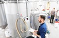 Man with clipboard at craft brewery or beer plant Royalty Free Stock Photo