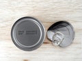 manufacturing date and expiry date printed on bottom of aluminum can and bent lid with pull ring on wooden kitchen table counter