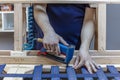 Male carpenter repairing wooden armchair in small business woodwork workshop