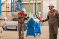 Manufacture workshop. move the crane with beam. Workers adjusts the machine in the warehouse. the production of Royalty Free Stock Photo