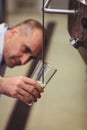 Manufacturer filling beer from storage tank at brewery Royalty Free Stock Photo