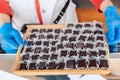 Manufacturin for automatic production of chocolate. Worker is holding tray of sweets. Sweets modern factory. Food