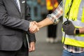 Manufacturing staff engineer in production factory hand shaking with businessman