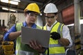 Manufacturing worker. Confident male workers with laptop at manufacturing plant. Concentrated workers showing control machine on