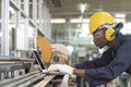 Manufacturing worker. Professional African-American worker uesing laptop controlling the work. Cheerful Factory Worker Posing