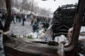 Many active people walk around the winter snowy street with burned cars and buses during anti-government protest Euromaidan