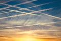 Lots of airplane vapor trails on a blue sky at sunset