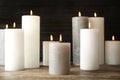 Many alight wax candles on table