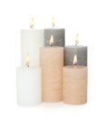 Many alight wax candles on white