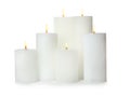 Many alight wax candles on white