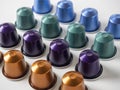 Many aluminum coffee capsules are displayed in a row on a white background. Food pattern. Capsules for the coffee machine