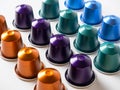 Many aluminum coffee capsules are displayed in a row on a white background. Food pattern. Capsules for the coffee machine