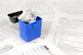 Many american tax blank forms and crumpled hundred dollar bill in trash bin