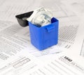 Many american tax blank forms and crumpled hundred dollar bill in trash bin