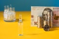 Many ampoules with vaccine and Ukrainian 100 hryvnia banknote and coins on a yellow-blue background. Medicine concept Royalty Free Stock Photo