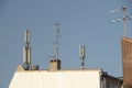 Many antennas on the roof of an urban house