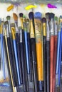 Brushes for painting and colored oil paints lie on palette in the artist`s studio Royalty Free Stock Photo