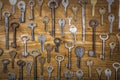 Many assorted old multi-colored metal antique vintage keys of different shapes on wooden scratched table background. Home security Royalty Free Stock Photo