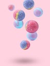 Many different bath bombs falling on pastel pink background Royalty Free Stock Photo