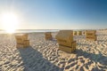 Many beach chairs at the ocean with scenic lens flare during beautiful sunset on the island of Sylt in Germany