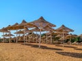 Many beach umbrellas woven from dry grass on the sand in Sharm El Sheikh Egypt. Hotel tropical beach, no people, background with Royalty Free Stock Photo