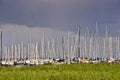 Many beautiful sailing boats with high poles in a small marina near Flensburg/Germany in front of cloudy and windy sky