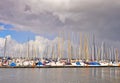 Many beautiful sailing boats with high poles in a small marina near Flensburg/Germany in front of cloudy and windy sky