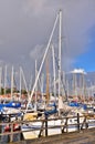 Many beautiful sailing boats with high poles in a small marina near Flensburg/Germany in front of cloudy and windy sky