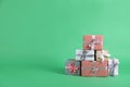 Many beautifully wrapped gift boxes on green background. Space for text