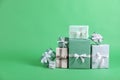 Many beautifully wrapped gift boxes on green background. Space for text