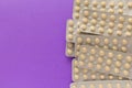 Beige pills inside medicine box. Violet background. Royalty Free Stock Photo