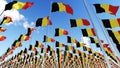 Many Belgium Flags against blue sky.