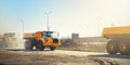 Many big articulated heavy industrial yellow dumper trucks driving on new highway road construction site on sunny day with blue